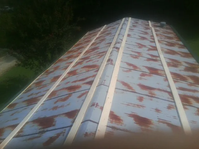 Rusted metal roof panels with new wood purlins before replacement — Storm Damage Roof Repair in Big Arm by Roofing Brothers